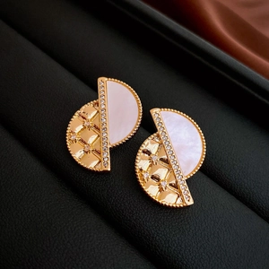 Close-up of vintage geometric earrings with mother-of-pearl and quilted gold texture