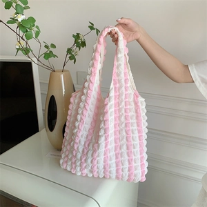 Close-up of pink and white bubble texture fabric on a stylish tote bag held by hand