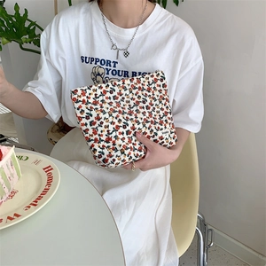 Détail d'une trousse à maquillage vintage en velours côtelé avec motif floral et étiquette