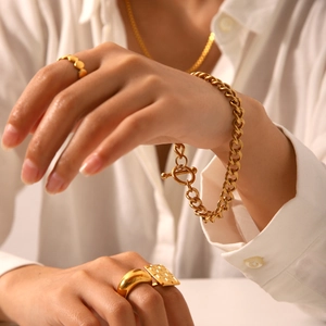Detailed view of 18K gold plated OT buckle Cuban chain bracelet and geometric rings