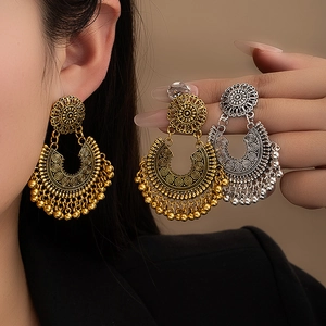 Detailed macro view of bohemian vintage floral earrings with crescent metal fringe tassels