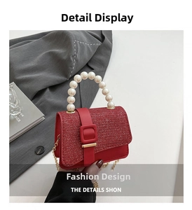 Detail of red square bag featuring sequin flap, large pearl handle, and gold metal clasp
