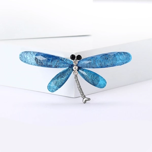 Macro detail of dragonfly brooch wings with blue fibrous texture and sparkling rhinestones
