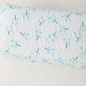 Close-up of white seersucker fabric pencil case with blue floral pattern and soft texture