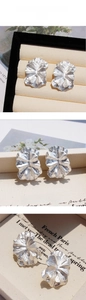 Gros plan de boucles d'oreilles pétales argentées double épaisseur au style rétro chic