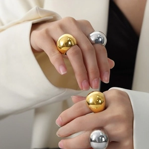 Close-up of polished gold and silver dome rings on model hand for a trendy style