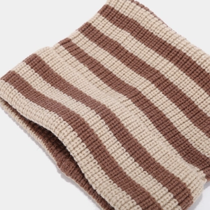 Gros plan sur la texture tricotée rayée épaisse d'un bonnet marron et beige chaud