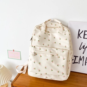 Detailed view of floral backpack on a wooden table with warm indoor background
