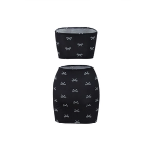 Detailed view of black tube top and mini skirt set with white bow patterns on a flat model