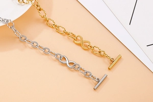 Detail of stainless steel infinity link bracelet in gold and silver with T-bar closure