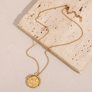 Detailed macro view of 18K gold plated moon and star coin pendant with crystal inlay