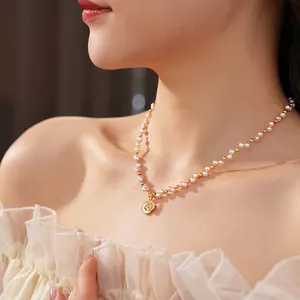 Elegant pearl choker necklace with a gold zircon starburst pendant worn by a model