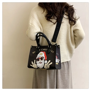 Detail of Santa Claus print on black leather tote bag with wide fashion shoulder strap