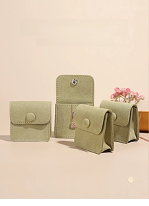 Detail of green microfiber jewelry pouch with metal snap button and decorative button closure