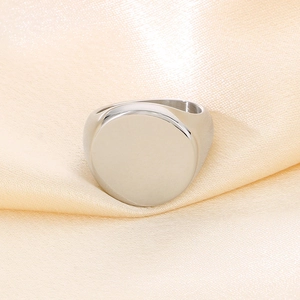 Dettaglio macro di un anello a sigillo in acciaio inossidabile su seta champagne