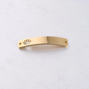 Detail of golden stainless steel curved rectangular connector with crown cutout