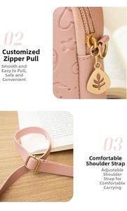Detailed view of pink leather bag featuring leaf zipper pull and adjustable shoulder strap
