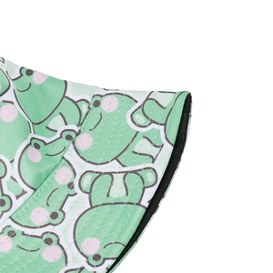 Close-up of green bucket hat showing cute cartoon frog patterns and double-stitched brim