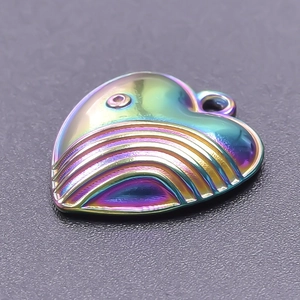 Macro shot of rainbow-colored heart pendant with metallic texture and raised lines