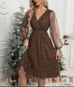 Close-up of brown V-neck dress featuring mesh sleeves and shimmering gold sequins