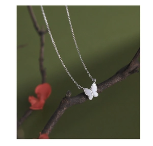 S925 silver butterfly pendant necklace with white mother of pearl on a dark branch