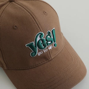 Brown cotton baseball cap with green Yes embroidery and curved brim for kids