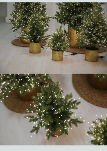 Detail of mini glowing Christmas tree with warm white LED lights and golden metal base