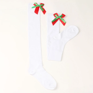 Close-up of white festive stockings with silk red and green bow detail on top