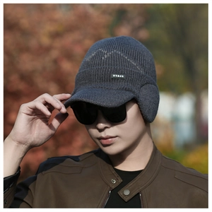 Detail of dark grey men's winter knitted hat with ear flaps and NY&JA logo label