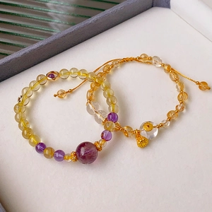 Detailed view of Chinese style bracelets with amethyst, citrine and golden lotus charms