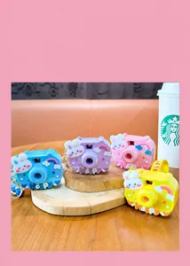 Close-up of colorful rabbit-themed projection camera keychains on a wooden table