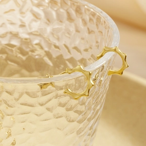Vintage gold irregular C-shape hoop earrings with bamboo texture on a glass rim