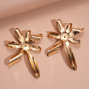 Close-up of golden double-layer flower earrings with intricate metal petals and texture