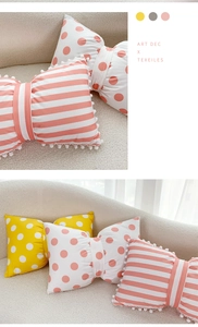 Detail of velvet bow pillows in striped and polka dot patterns with soft pom-pom fringe