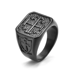 Macro detail of vintage black titanium steel ring with embossed shield and cross design