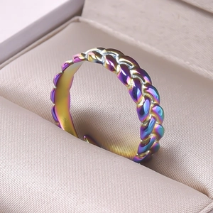 Close-up of rainbow gradient woven texture on an adjustable stainless steel open ring