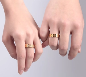 Close-up of golden couple rings featuring a minimalist smooth band and a diamond-pave style