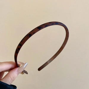 Detail shot of leopard print headband showing interior teeth and flexible frame