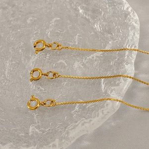 Close-up of 18K gold-plated spring ring clasp on minimalist stainless steel chain
