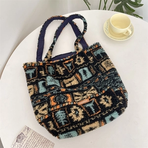 Detail of plush geometric tote bag with branded leather tag and navy blue lining