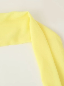 Close-up of bright yellow chiffon fabric showing soft drape and lightweight texture