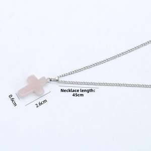 Macro shot of pale pink crystal cross pendant with silver chain measuring 2.6cm high
