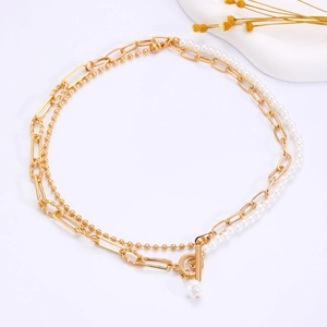 Detail of double-layer gold chain necklace with white pearls and T-bar toggle clasp