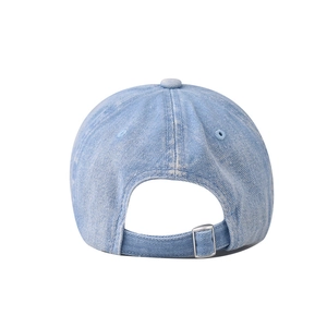 Detail of light blue washed denim baseball cap with adjustable silver metal buckle