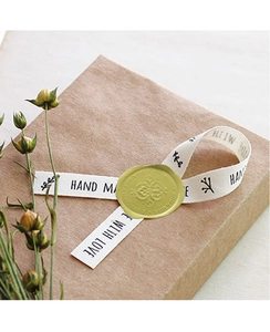Close-up of gold wax seal with Especially For You text on a gift box with handmade ribbon