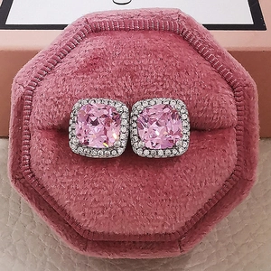 Macro detail of cushion-cut pink zircon stud earrings with halo setting in velvet box