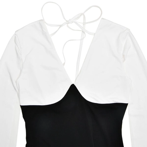 Detail of V-neck heart-shaped bodice and white tie-back straps on sleek black maxi dress