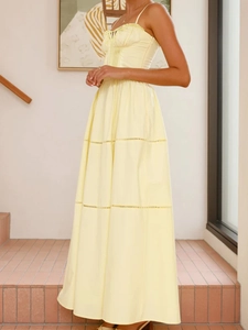 Detail of light yellow tiered maxi dress featuring ruched bodice and camisole straps