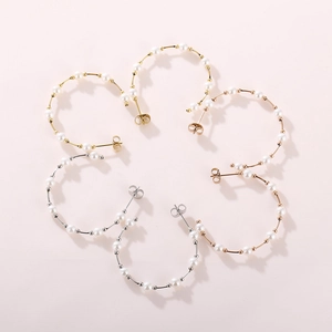 Detailed close-up of pearl C-shaped hoop earrings in gold, silver, and rose gold finishes