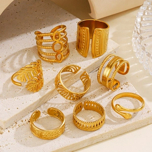 8-piece 18K gold plated leaf and geometric stainless steel rings set on marble base